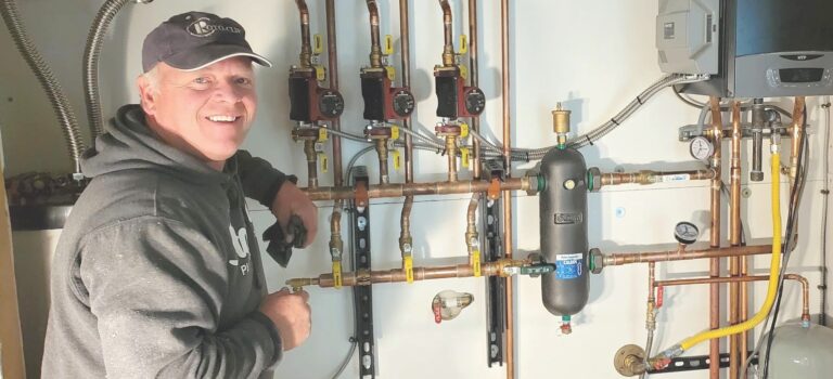 man installing a manifold for heating system